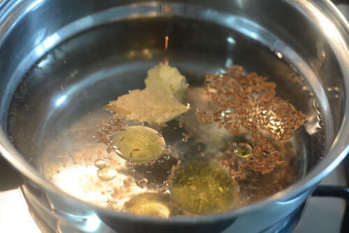 Bring the water to a rolling boil and add 1 tsp caraway seeds (shahjeera), 2 bay leaves, 1 tsp oil, and some salt
