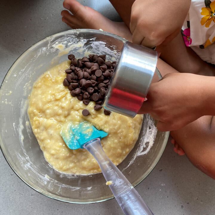 adding chocolate chips into chocolate chip banana bread