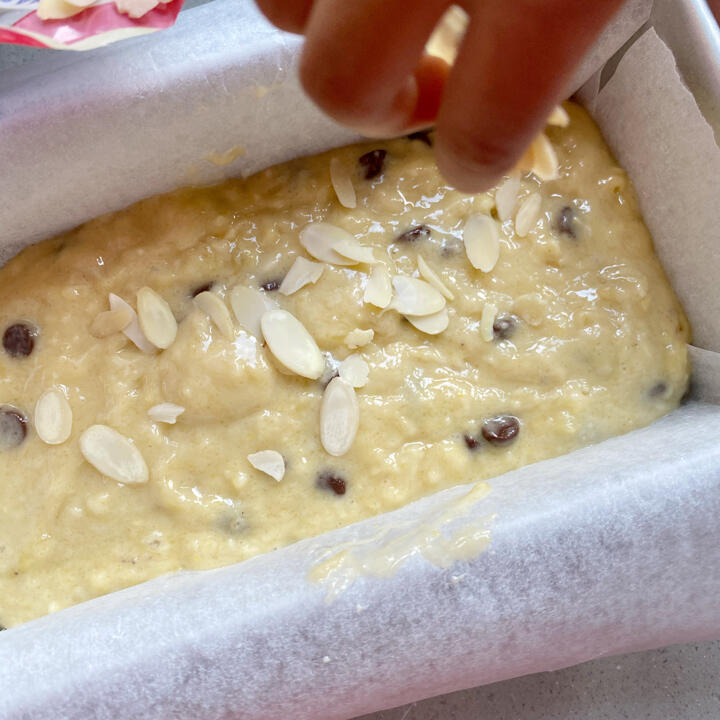 adding almond flakes to chocolate chip banana bread